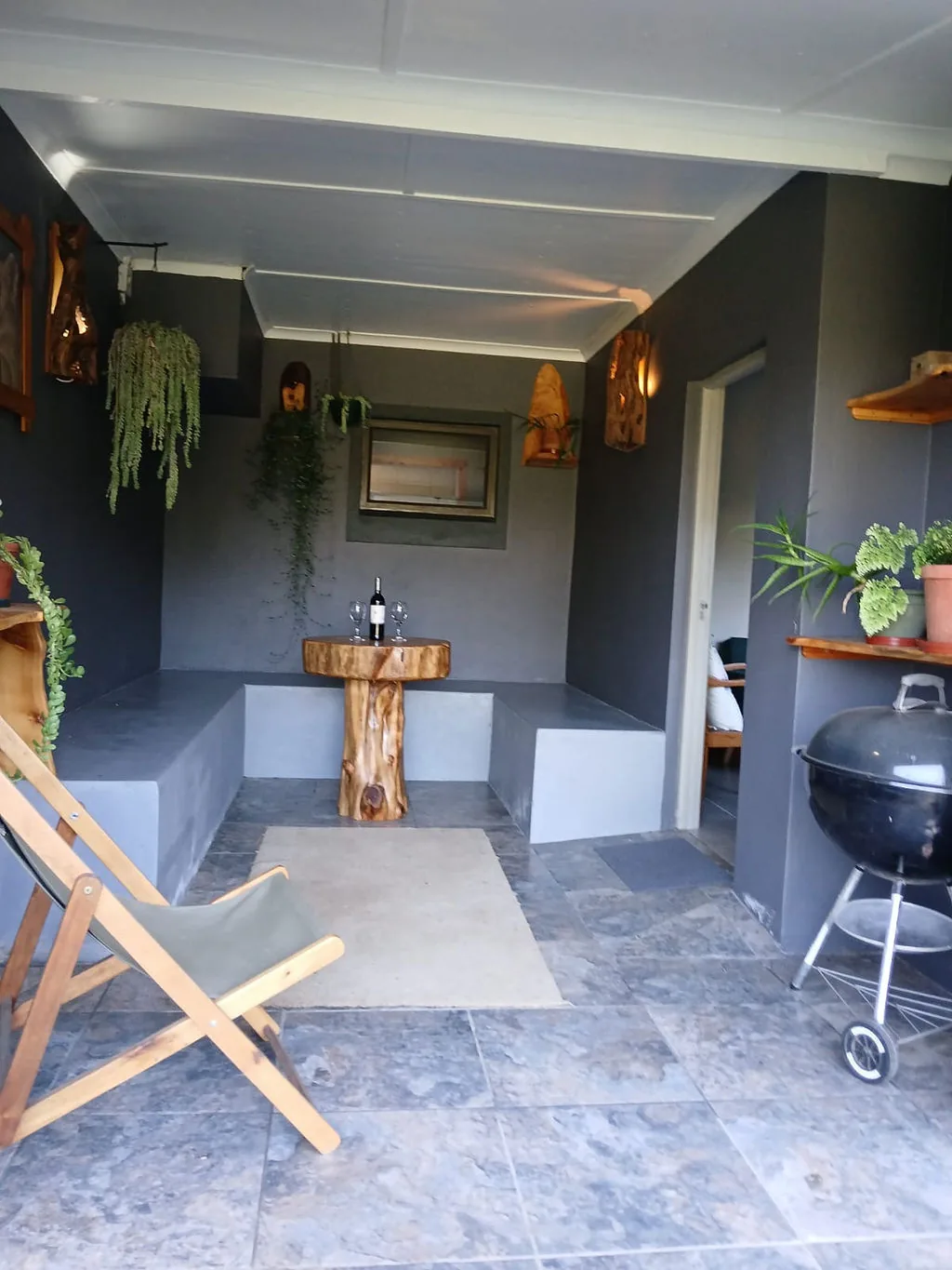 Enclosed veranda with braai and seating at The Wood Haven