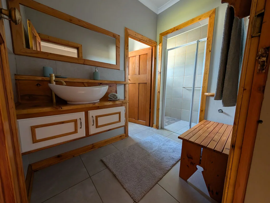 Bathroom with walk-in shower and handcrafted timber finishes at The Wood Haven